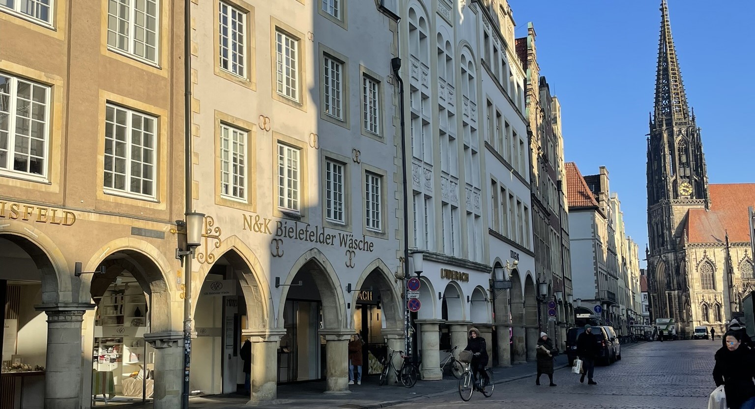 N&K Bielefelder Wäsche Münster am Prinzipalmarkt, Geschäft in der Morgensonne im Hintergrund die Ludgerikirche zu sehen.